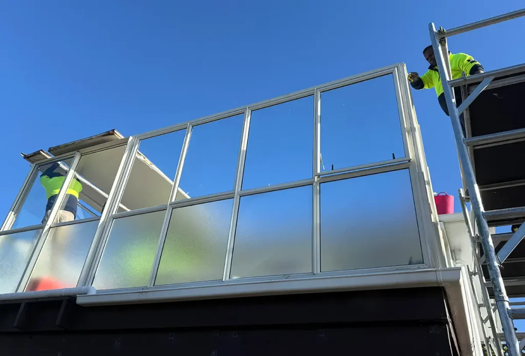 Workers installing a new roof on an existing conservatory